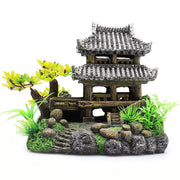 Two-story Asian pagoda aquarium decoration with grey tiled roofs, artificial plants and rocks