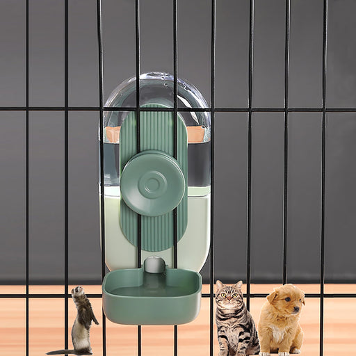 Green hanging water dispenser mounted on pet cage bars with cats and puppy looking up from below