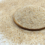 Premium beige aquarium sand substrate with wooden measuring ruler showing fine grain texture