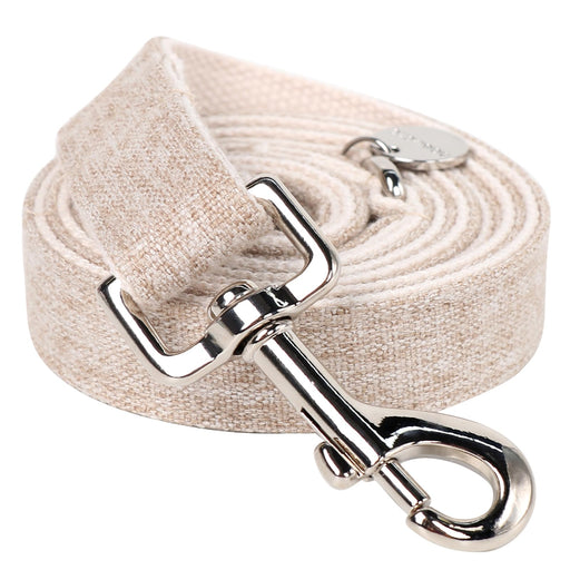 Beige cotton hemp dog leash with metal swivel clasp coiled on white background