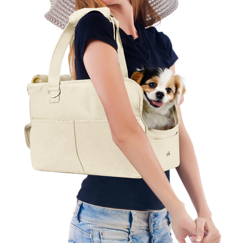 Woman wearing beige oxford dog carrier purse with small Chihuahua puppy peeking out from front