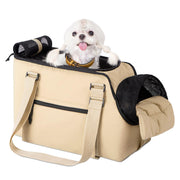 Small white dog with pink tongue sitting in beige soft-sided pet carrier with mesh ventilation