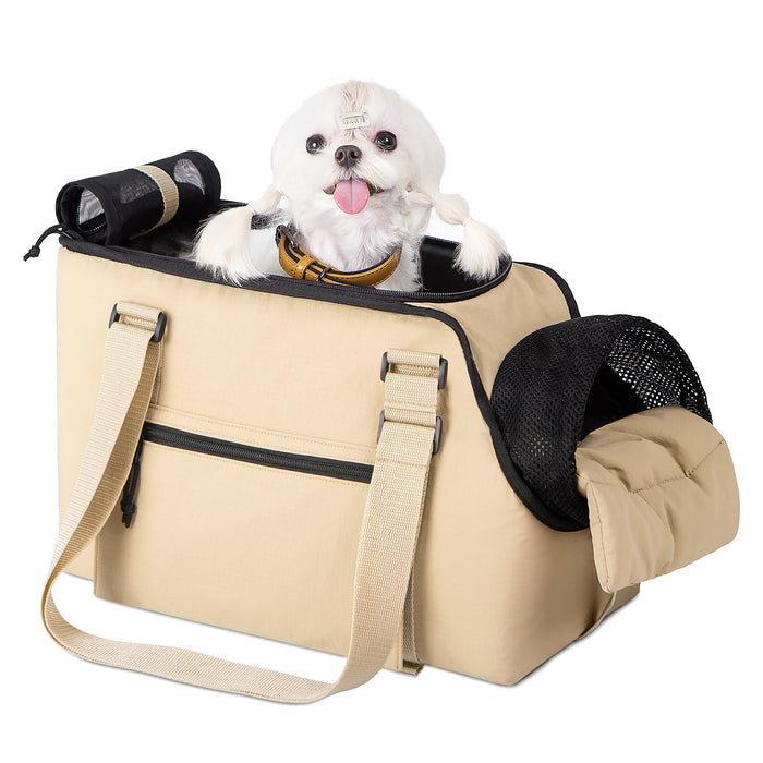 Small white dog with pink tongue sitting in beige soft-sided pet carrier with mesh panels