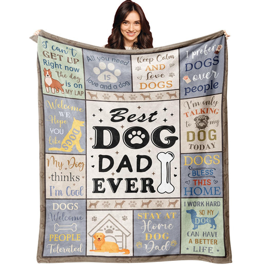 Woman holding up colorful dog dad themed blanket with paw prints and humorous sayings