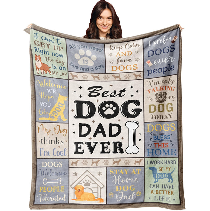 Woman holding up colorful dog dad themed blanket with paw prints and humorous sayings
