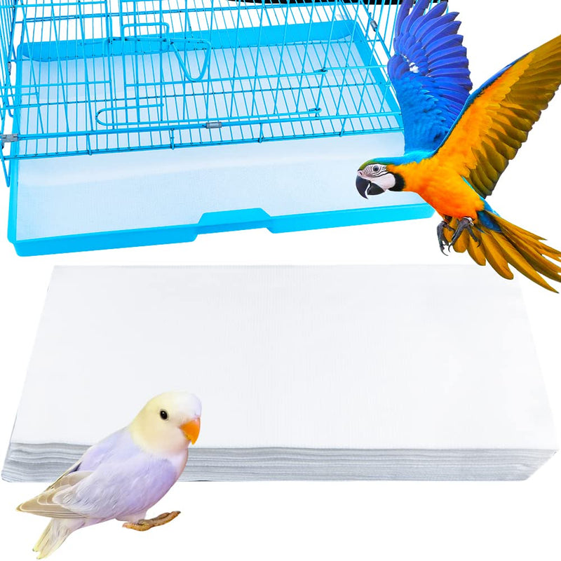 Bird cage liner papers stacked beside blue cage with macaw and white cockatiel