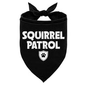 Black dog bandana with white SQUIRREL PATROL text and paw print shield logo on triangular fabric