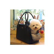 White fluffy small dog sitting inside black leather travel carrier bag with stuffed animals
