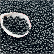 Black glass aquarium substrate sand scattered with white shell bowl containing sample of beads