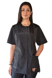 Woman wearing black waterproof pet grooming smock with short sleeves and front pockets