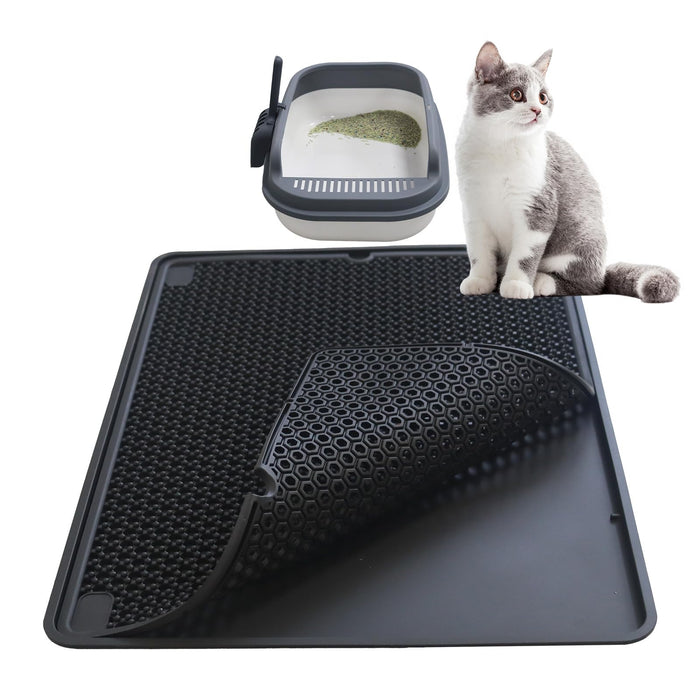 Gray and white cat sitting beside black double layer litter mat with hexagonal pattern and