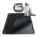 Gray and white cat sitting beside black double layer litter mat with hexagonal pattern and