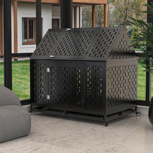 Black steel dog kennel with house-shaped roof and perforated walls on outdoor patio