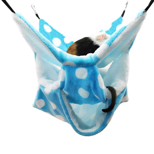 Guinea pig resting in blue polka dot fleece hammock with white fuzzy lining and black hooks