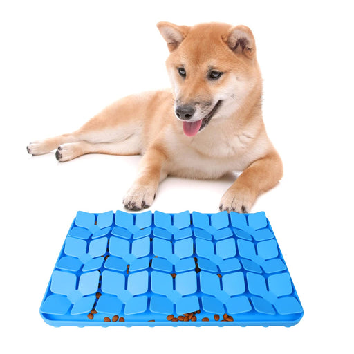Tan Shiba Inu dog lying with paws on blue silicone puzzle feeding mat with kibble