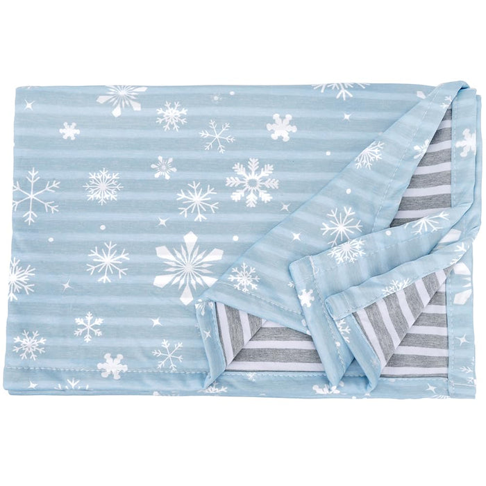 Light blue dog blanket with white snowflake pattern, corner folded to show gray striped reverse side