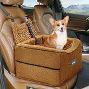 Orange corgi sitting in brown quilted dog car booster seat with safety straps in vehicle interior