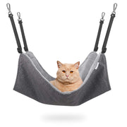 Orange cat sitting comfortably in gray fabric hammock with black adjustable straps