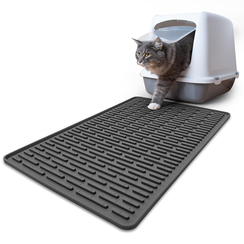 Gray tabby cat stepping out of hooded litter box onto black silicone mat with raised ridges