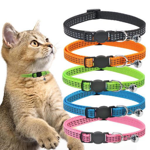 Cat wearing green reflective collar sits beside five colorful breakaway collars with bells