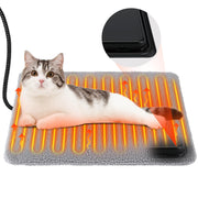 Gray and white tabby cat lying on heated pet pad with orange heating elements glowing
