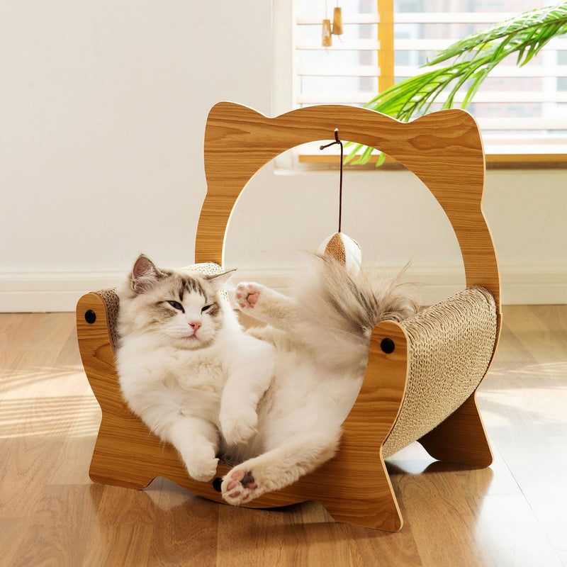 Fluffy white and gray cat relaxing inside wooden cat-shaped scratcher with dangling ball toy