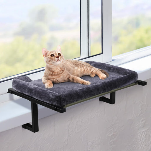 Orange tabby cat lounging on gray cushioned window perch with black metal frame by sunny window