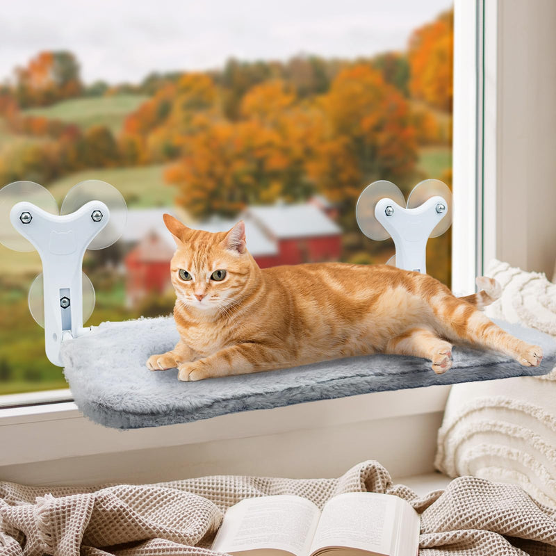 Orange tabby cat relaxing on gray cushioned window perch with white suction cup mounts
