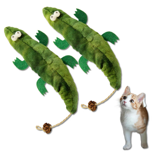 Two green plush crocodile catnip kicker toys with rope tails beside an orange and white kitten