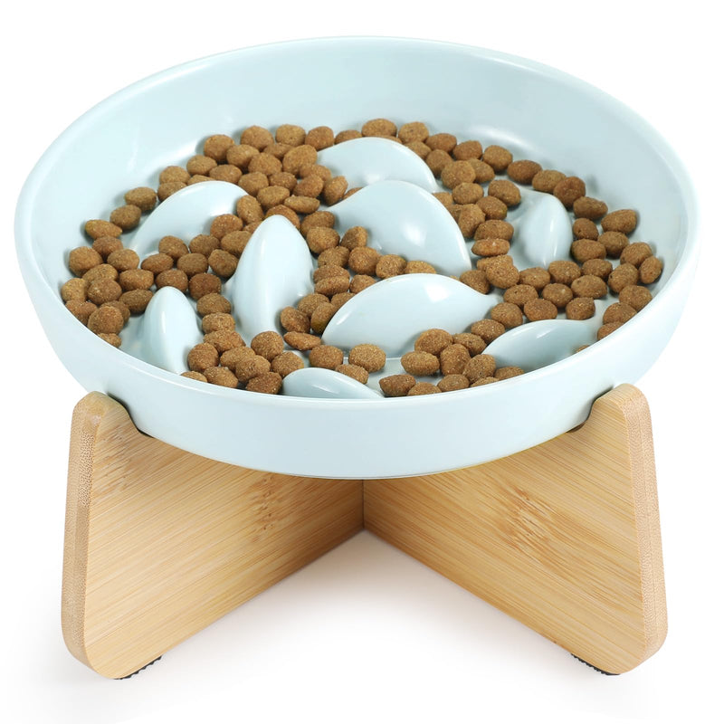 White ceramic slow feeder bowl with raised ridges filled with brown kibble on bamboo stand