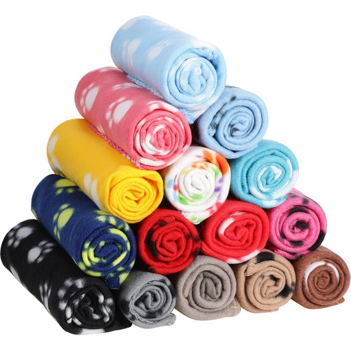 Stack of colorful rolled fleece pet blankets with paw print patterns in various colors