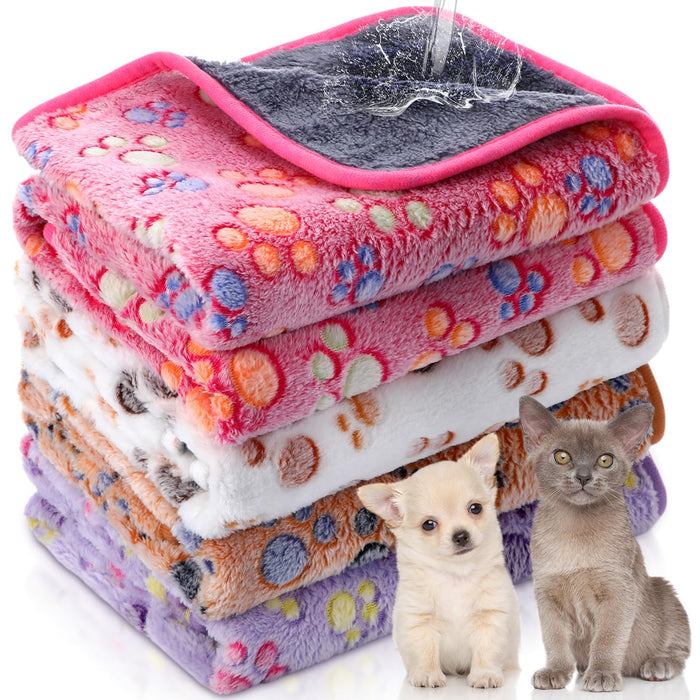 Stack of colorful waterproof pet blankets with paw print patterns alongside small dog and cat
