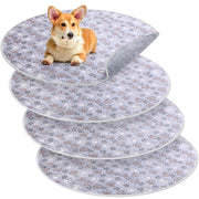 Corgi puppy sitting on top of stacked washable dog training pads with paw print pattern