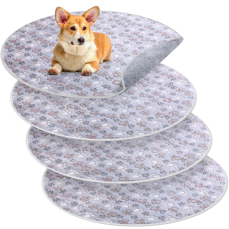 Corgi puppy sitting on top of stacked washable dog training pads with paw print pattern