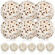 Six white cylindrical rattan foraging balls and six woven rattan spheres arranged on white