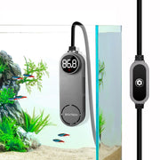 Gray digital aquarium heater with 86.8°F display and control dial next to fish tank with plants