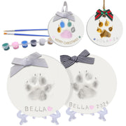 DIY clay paw print keepsake kit showing two white ornaments named Bella with paints and brushes