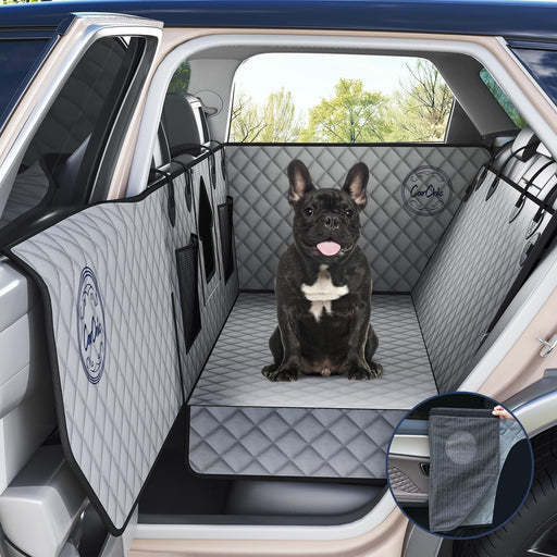 French bulldog sitting in car backseat on gray quilted waterproof seat cover with door panels