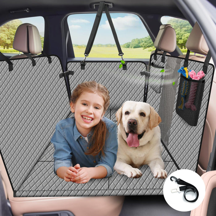 Young girl and yellow Labrador sitting on gray quilted car seat cover with mesh barrier and