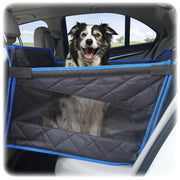 Happy border collie dog sitting in gray and blue quilted car seat extender in back seat
