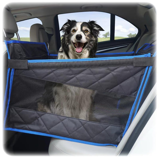 Black and white dog sitting happily in gray quilted car seat extender with blue trim