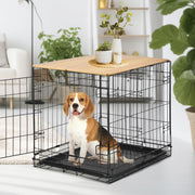 Beagle sitting inside black wire dog crate with wooden table top in modern living room