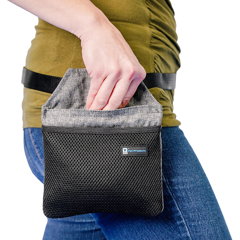 Person reaching into gray and black dog treat pouch attached to belt showing easy access design