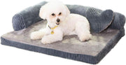 White fluffy dog lying on gray corduroy L-shaped orthopedic bed with raised sides