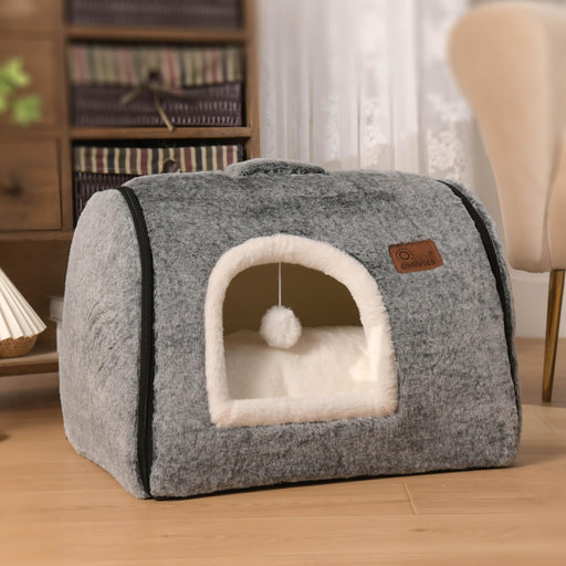 Gray enclosed cave cat bed with white interior cushion and hanging pom-pom toy