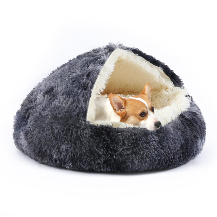Small orange and white Corgi dog nestled inside gray hooded cave pet bed with cream interior