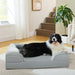 Black and white Border Collie lying on gray orthopedic dog bed in modern living room setting