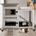 Gray wooden two-story small animal hutch with guinea pigs inside and on floor in home setting