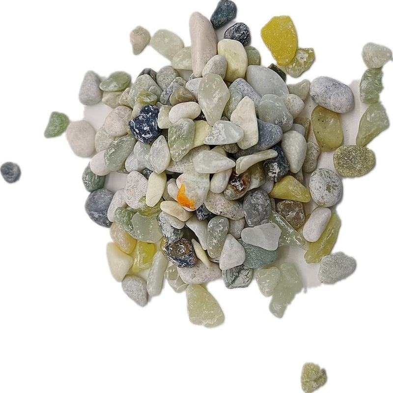 Pile of natural green aquarium gravel stones in various shades scattered on white background