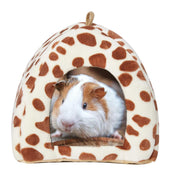 White and brown guinea pig inside cream colored spotted cave bed with brown dots